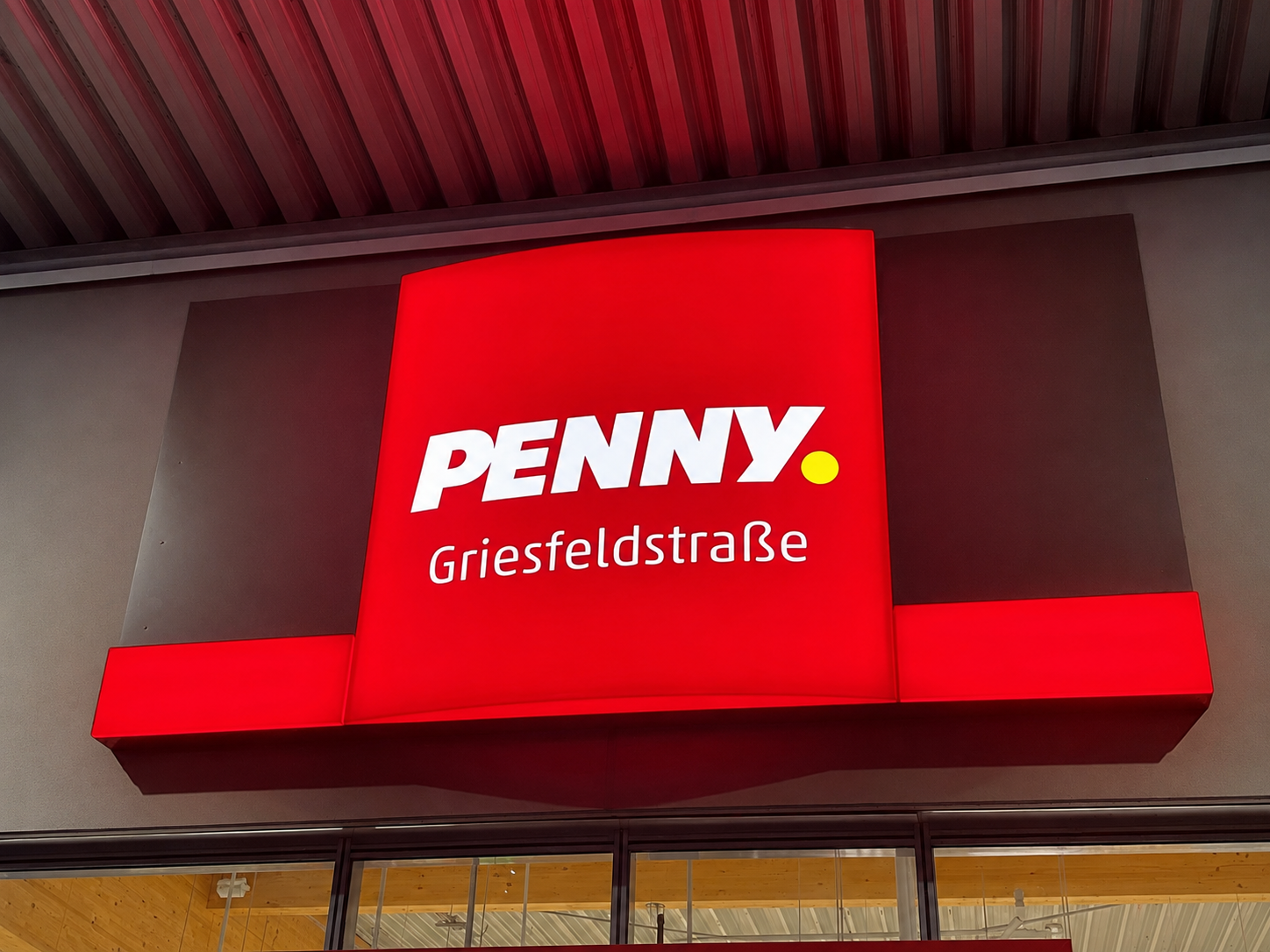 Großflächiger roter PENNY Leuchtkasten mit gleichmäßig ausgeleuchteter Ansichtsfläche