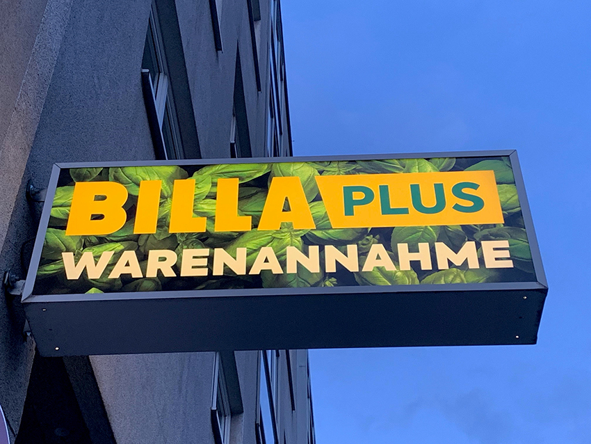 Leuchtkasten als Ausleger mit Digitaldruckmotiv an einer Hausfassade