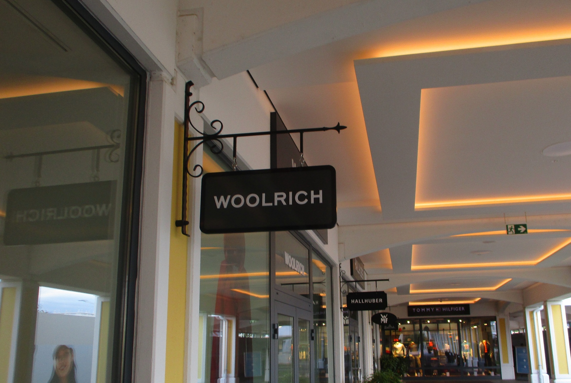 Beleuchtetes Woolrich-Nasenschild im Shop-Bereich des Outlet Centers