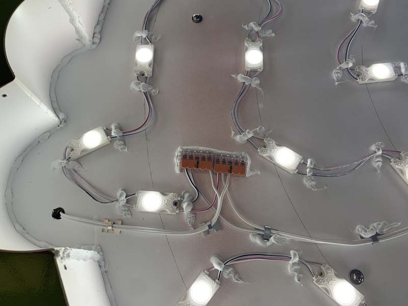 Innenleben eines runden Leuchtkastens mit gleichmäßig verteilten LED-Modulen auf weißem Untergrund
