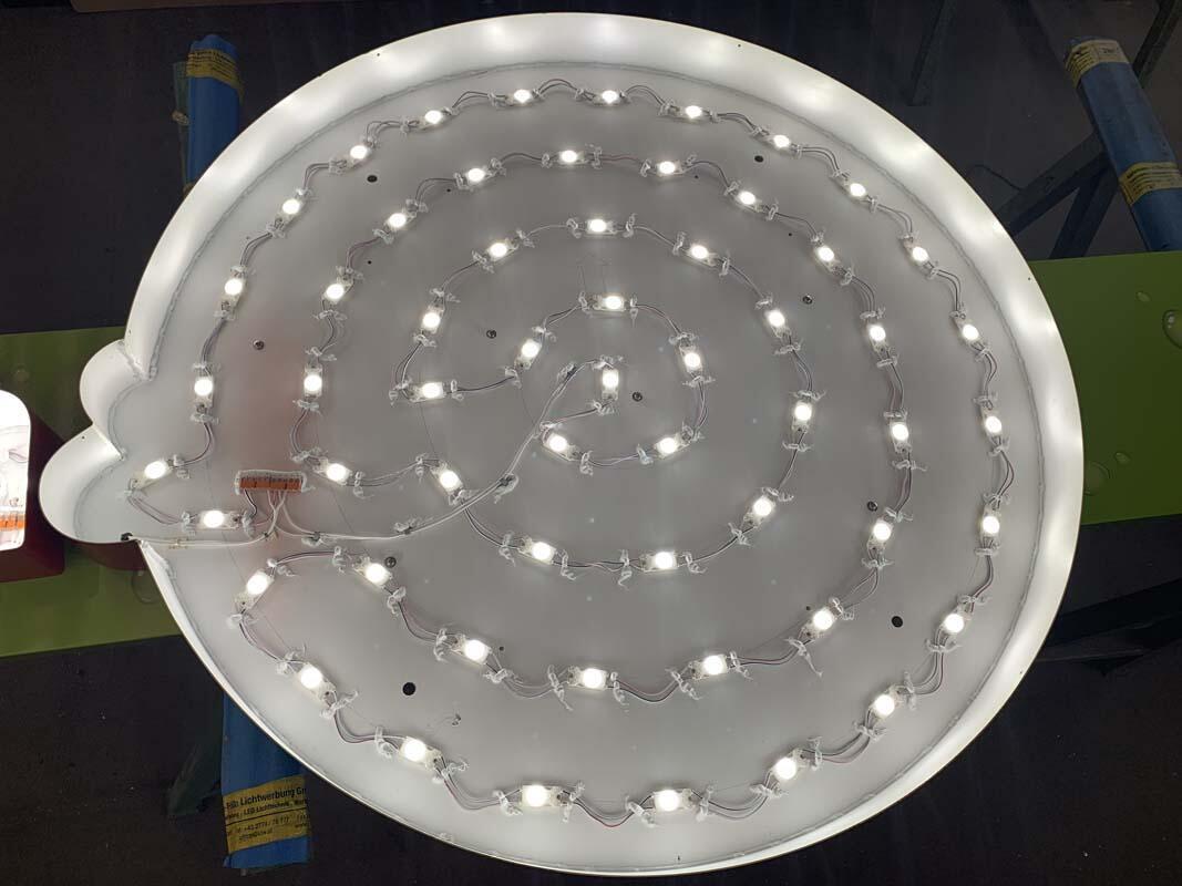 Großer runder Leuchtkasten von innen mit hell leuchtenden LED-Modulen in spiraliger Anordnung