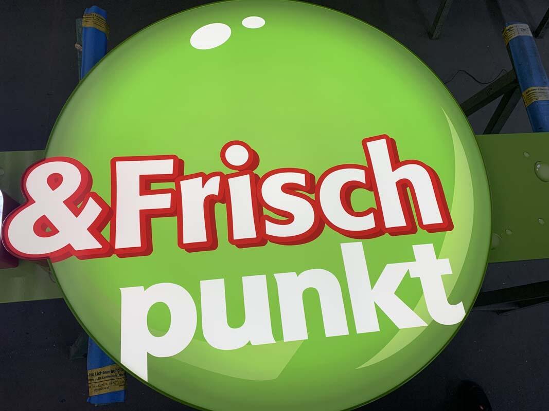 Fertiges, gleichmäßig ausgeleuchtetes Frischpunkt-Logo als kantenbeleuchteter Leuchtkasten