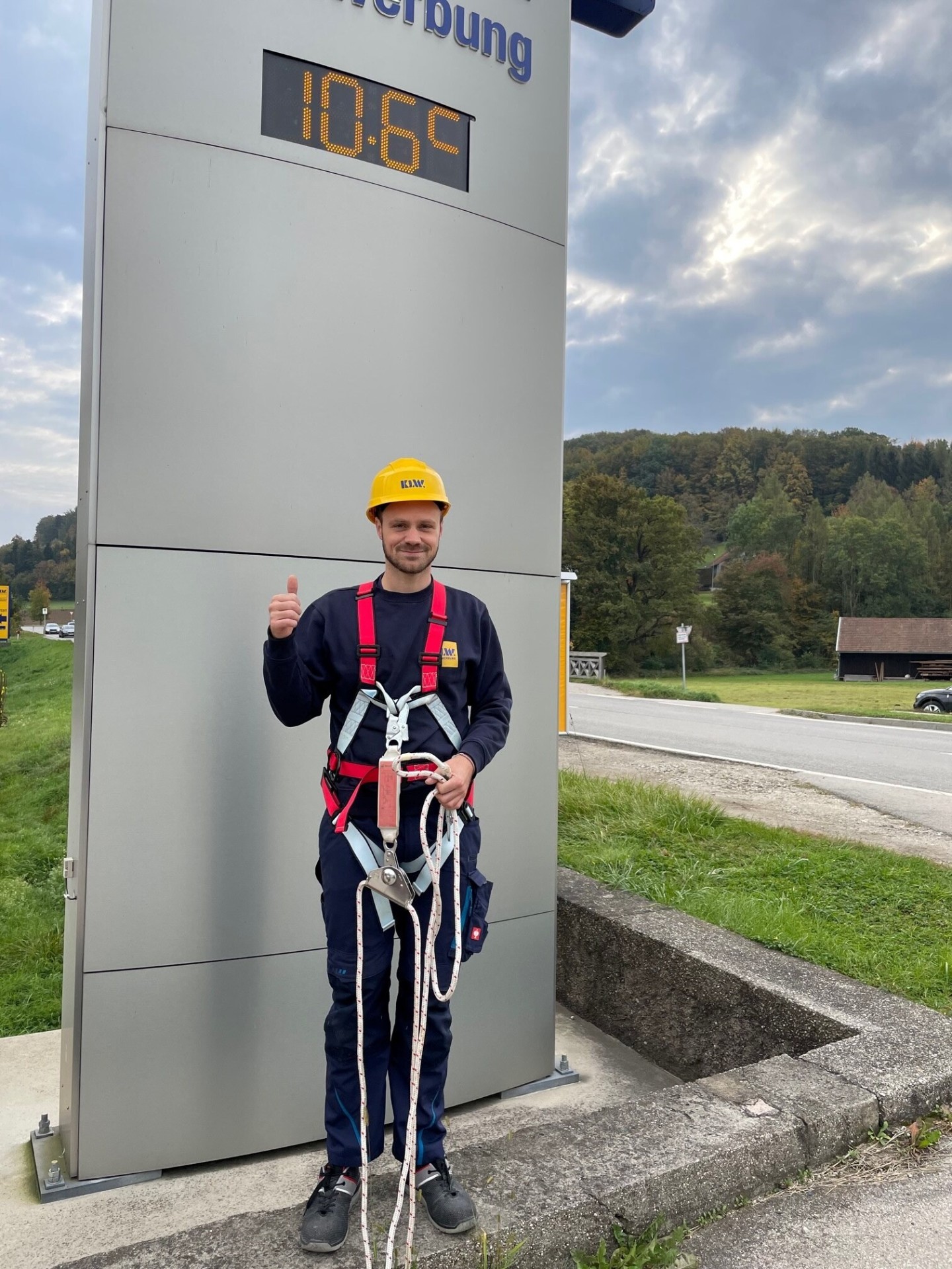 KLW Monteur mit Auffanggurt und Sicherungsseil vor einer Pylone