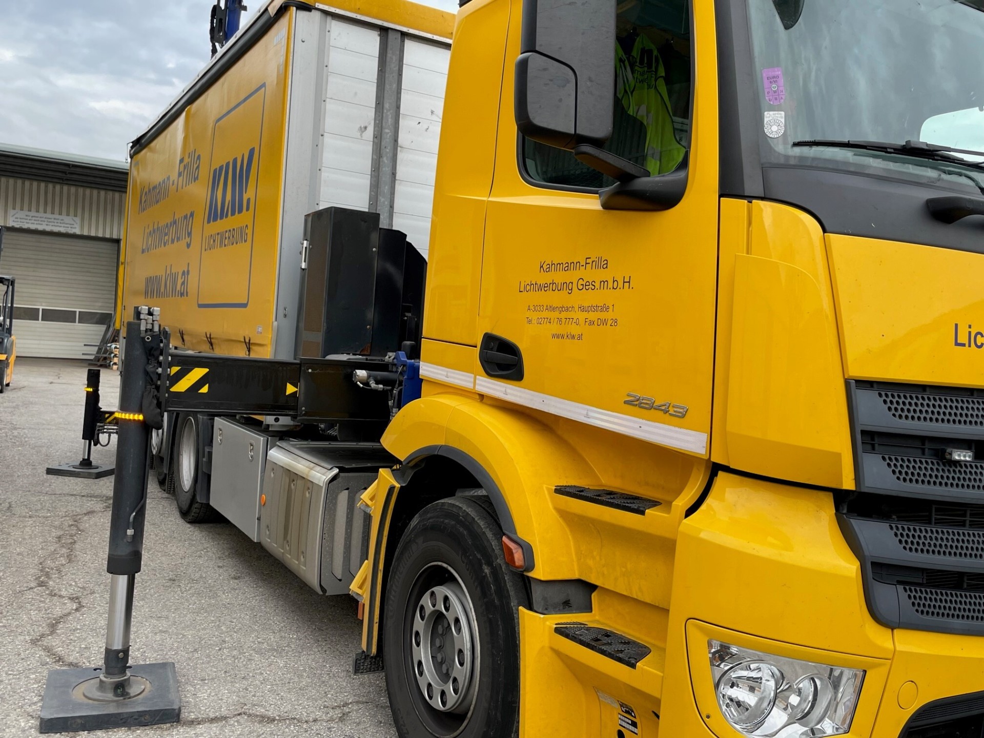 KLW Ladekran-LKW Mercedes Antos mit ausgefahrener Stützpfote auf der Baustelle