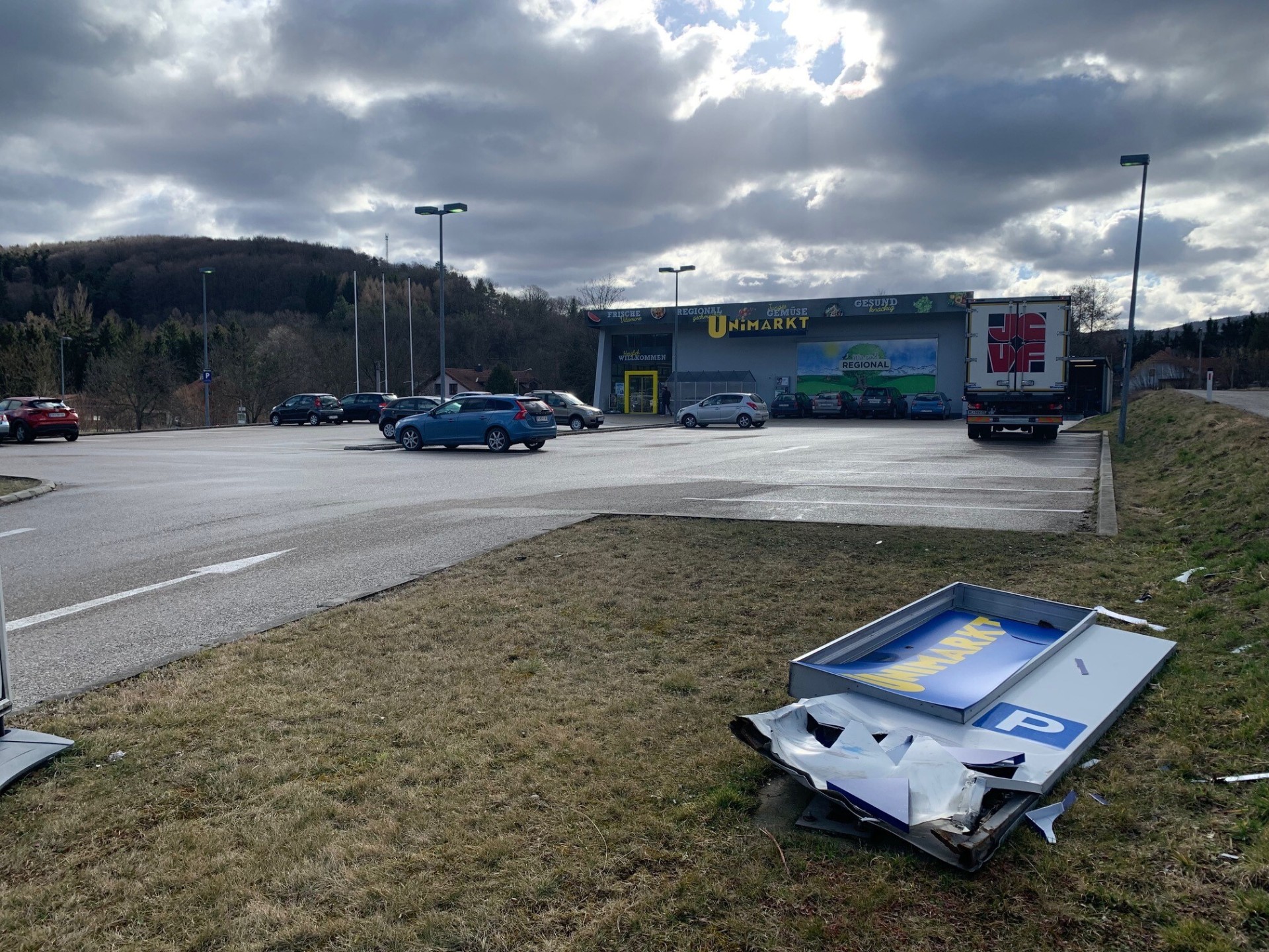 Unimarkt Standort mit umgestürztem Werbepylon auf der Wiese vor dem Geschäft