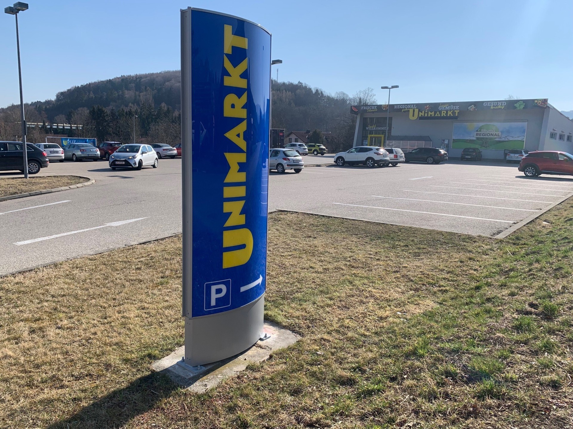 Neuer beleuchteter Unimarkt Werbepylon mit P-Symbol vor dem Markt nach Abschluss der Arbeiten