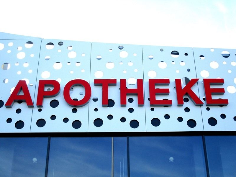 APOTHEKE Einzelbuchstaben rot auf perforierter Fassade