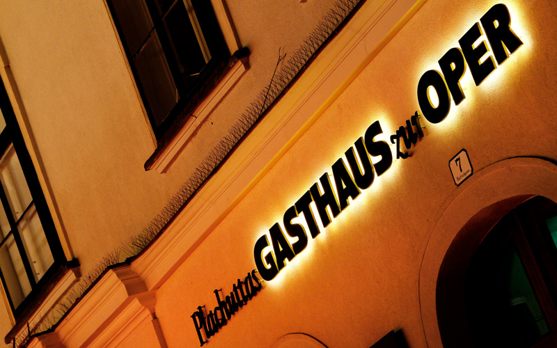 Superflache Buchstaben Gasthaus zur Oper – Fassadenschrift bei Nacht