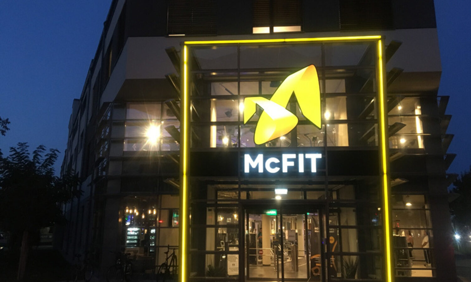 Torbogen McFIT – gelb beleuchteter Eingangsrahmen bei Nacht