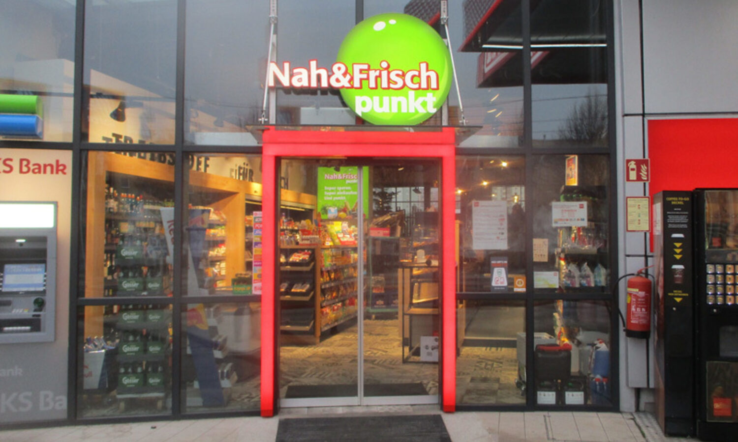Torbogen Nah & Frisch punkt – roter Eingangsrahmen mit Logo-Kugel