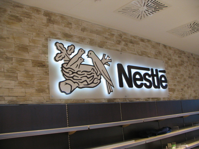 Superflache Buchstaben Nestlé – Logo mit Halo-Effekt