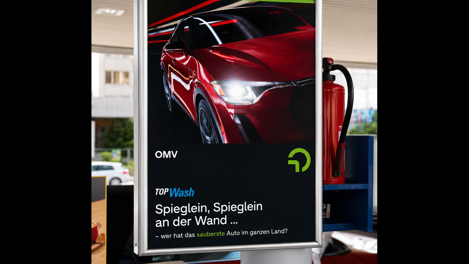 LED Posterrahmen OMV Top Wash mit rotem Auto Sujet an einer Tankstelle