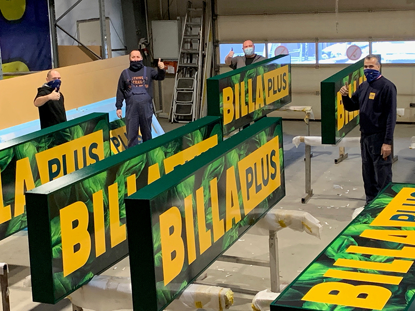 BILLA Plus – Montageteam von KLW vor fertigen Leuchtschildern