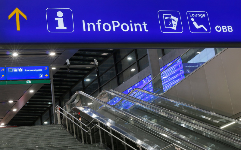 Großflächiges blaues Leitsystem InfoPoint und Lounge über Rolltreppe